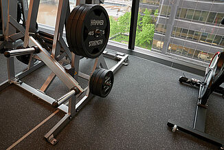 Weightlifting Area in Corporate Wellness Center A weightlifting area in a fitness center, featuring a rack of weights and a large glass wall.