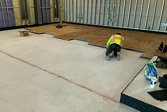 College of the Holy Cross- Installation Process of REGUPOL acoustics A construction employee installs the REGUPOL acoustic solutions to the flooring at the College of the Holy Cross Recreation and Wellness Center.
